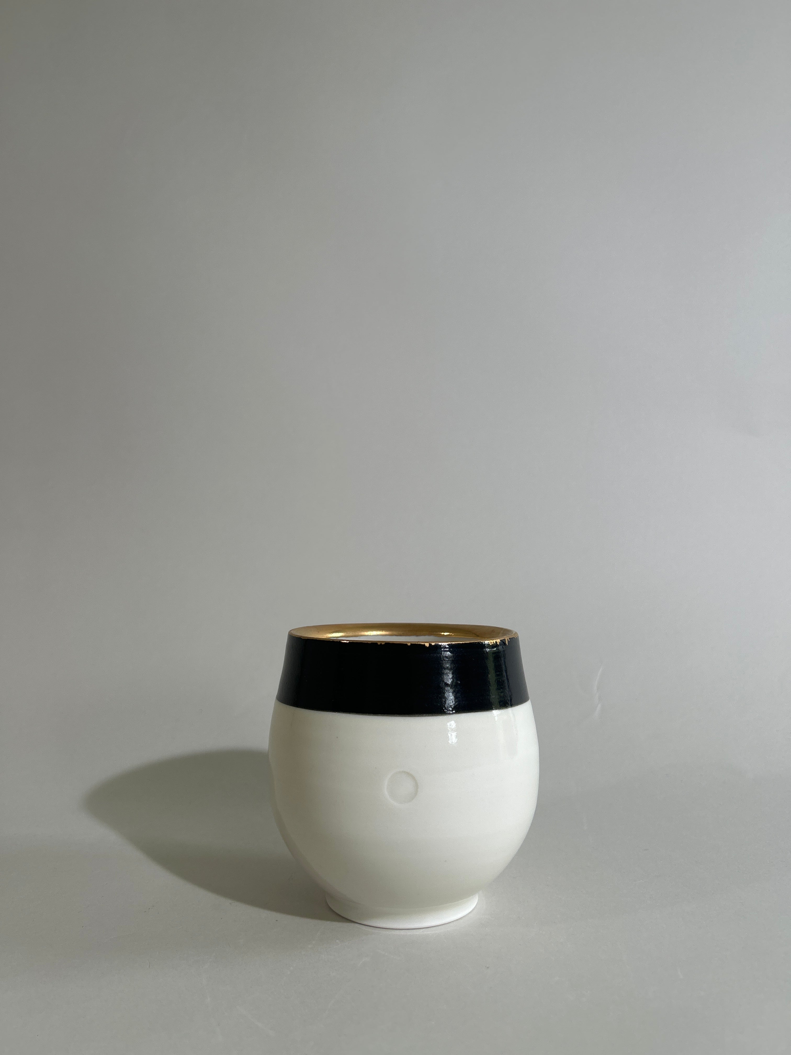 Porcelain cup with black and gold luster designs
